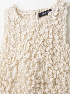 Detailed macro view of the popcorn pleated fabric and hidden back zipper of the dress