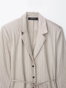 Detailansicht eines hellgrau gestreiften Blazers mit Revers und Taillengürtel-Detail