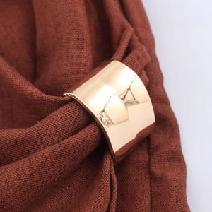 Golden wide metal decorative buckle with mirror finish on red textured linen fabric