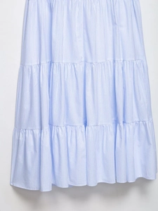 Détail d'une robe midi à rayures bleues et blanches montrant la texture et les plis