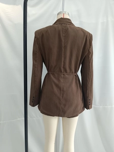 Rear view of brown drawstring waist blazer showing textured fabric and sleeve buttons