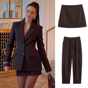 Detailed view of women's deep brown three-piece suit featuring blazer, skirt and trousers