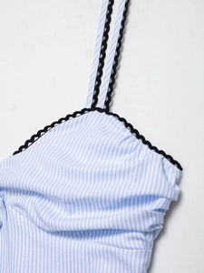 Détail d'un caraco à rayures bleues et blanches avec bordure ondulée noire décorative