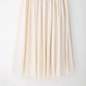 Elegant off-white pleated long maxi dress with minimalist accordion texture and fluid drape