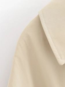 Detailed close-up of khaki trench coat collar stitching and premium twill fabric texture