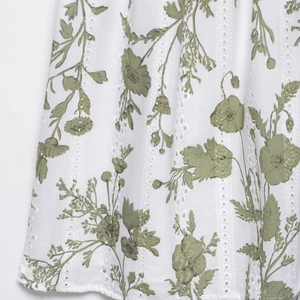 Abito bianco con ricamo inglese, stampa floreale verde e trama a righe verticali