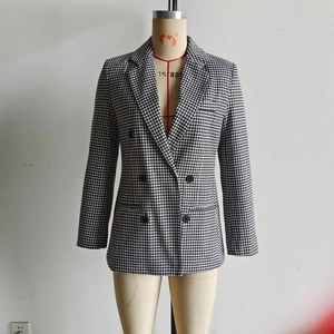 Detail of classic houndstooth pattern and double-breasted buttons on women's blazer
