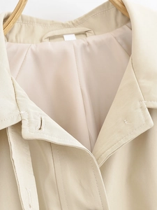 Detailed view of beige trench coat collar with premium stitching and cotton blend fabric