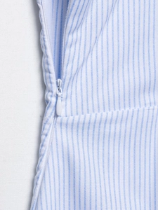 Détail de la fermeture éclair blanche sur une robe midi à rayures bleues et blanches