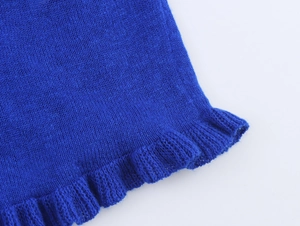 Detailed close-up of bright royal blue knit fabric with elegant ruffled hemline detail