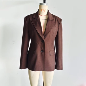 Detail of a dark brown double-breasted blazer with classic notched lapels and flap pockets