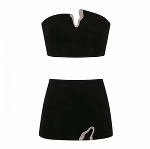 Detalle de los adornos de pedrería plateada en un conjunto negro de top corto y falda