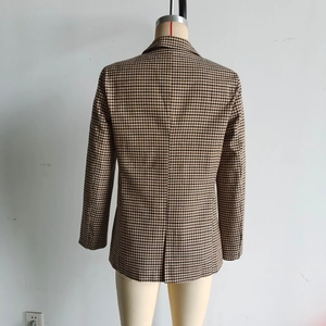 Detail view of the back tailoring and houndstooth pattern on the women's blazer