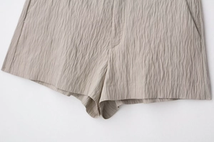 Makro-Detail der Textur des khakifarbenen Plissee-Stoffs und der Seitennaht-Tasche