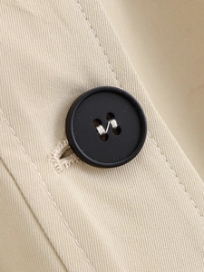Macro detail of high-quality resin button on beige twill cotton fabric for women coat