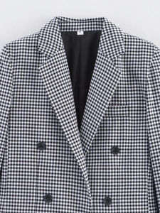 Detail shot of the double-breasted houndstooth blazer with notched lapels and black buttons
