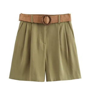 Detail of high-waist olive green Bermuda shorts with a straw belt and wooden buckle