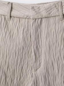 Detailansicht der beigen gestreiften Freizeithose mit Textur und präziser Taillennaht