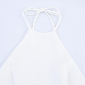 Detailed close-up of white halter neck dress featuring thin straps and a delicate back bow knot