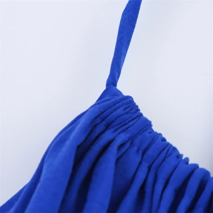 Détail rapproché du tissu plissé bleu et de la fine bretelle d'une robe midi d'été