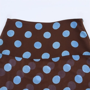 Detail view of the brown skirt featuring blue polka dots and hidden side zipper