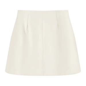 Vista detallada de una minifalda evasé color crema con costuras verticales decorativas