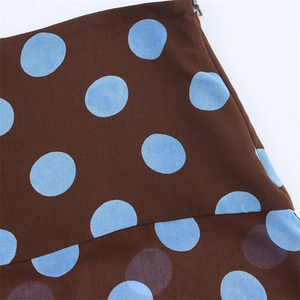 Detail of brown skirt fabric with blue polka dots and a hidden zipper closure