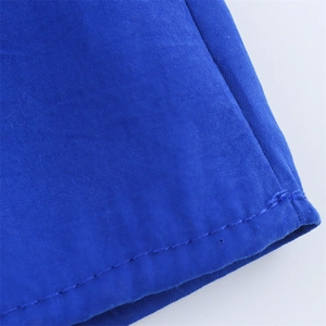 Gros plan détaillé des coutures propres sur l'ourlet du tissu bleu roi de la robe midi