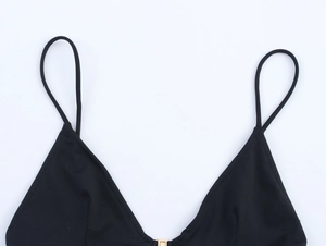 Detail of black triangle bikini top featuring thin straps and a gold square metal buckle