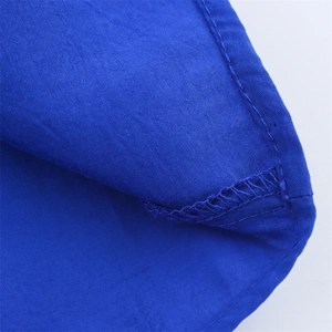Gros plan détaillé des coutures soignées et du surjet sur le tissu bleu roi de la robe midi