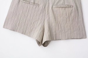 Detail der hellbraunen gestreiften Shorts mit Paspeltaschen und feiner Stoffstruktur