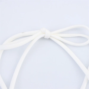 Detailed close-up of white fabric straps with handmade knot on a halter neck dress
