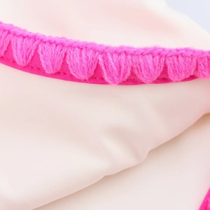Creamy white swimsuit with vibrant pink crochet heart-shaped trim detail and embroidery