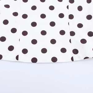 Gros plan du motif à pois noirs classiques sur le tissu blanc d'un haut ajusté élégant
