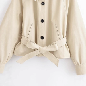 Short beige jacket with contrasting black buttons and tied waist belt decoration