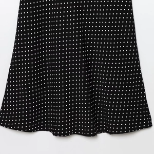 Elegant polka dot halter dress in classic black and white with flowing ruffled hemline