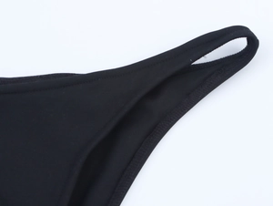 Detail view of double stitching on the waist and side seams of black bikini bottoms