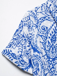 Détail du motif paisley bleu avec broderie anglaise ajourée sur un tissu d'été élégant