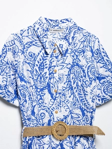Détail de robe d'été à imprimé paisley avec broderie et ceinture tressée sur blanc