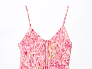 Détail de robe à fleurs col V montrant la taille smockée et le petit noeud