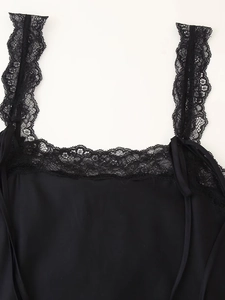 Dettaglio della canotta in raso nero con pizzo floreale delicato su scollo e spalline
