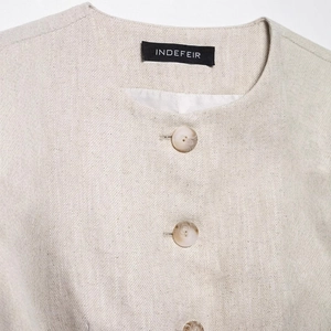 Minimalist beige sleeveless vest with twill fabric and decorative marble buttons