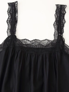 Dettaglio dell'elegante abito midi nero con intricato pizzo floreale sullo scollo a V