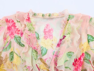 Dettaglio dello scollo a V con volant e stampa floreale su tessuto di chiffon rosa da donna