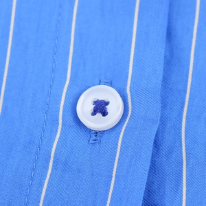 Detail of blue vertical striped shirt showing white button and high-quality twill fabric texture
