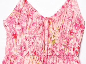 Détail de robe fleurie rose avec col en V à cordon et taille élastique froncée
