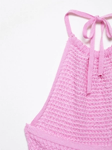 Detail of pink knitted halter dress neck with honeycomb texture and woven ribbons