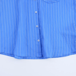 Detail of blue and white vertical striped shirt featuring a chest pocket and white buttons