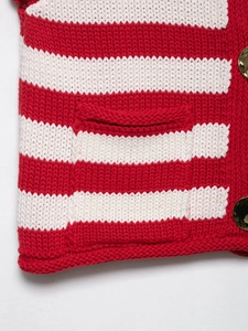 Detail der rot-weiß gestreiften Strickweste mit Goldknöpfen und einer strukturierten Tasche