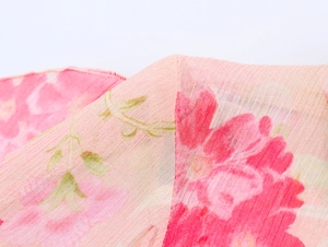 Dettaglio macro del tessuto in chiffon a fiori con delicati bordi rifiniti a sopraggitto